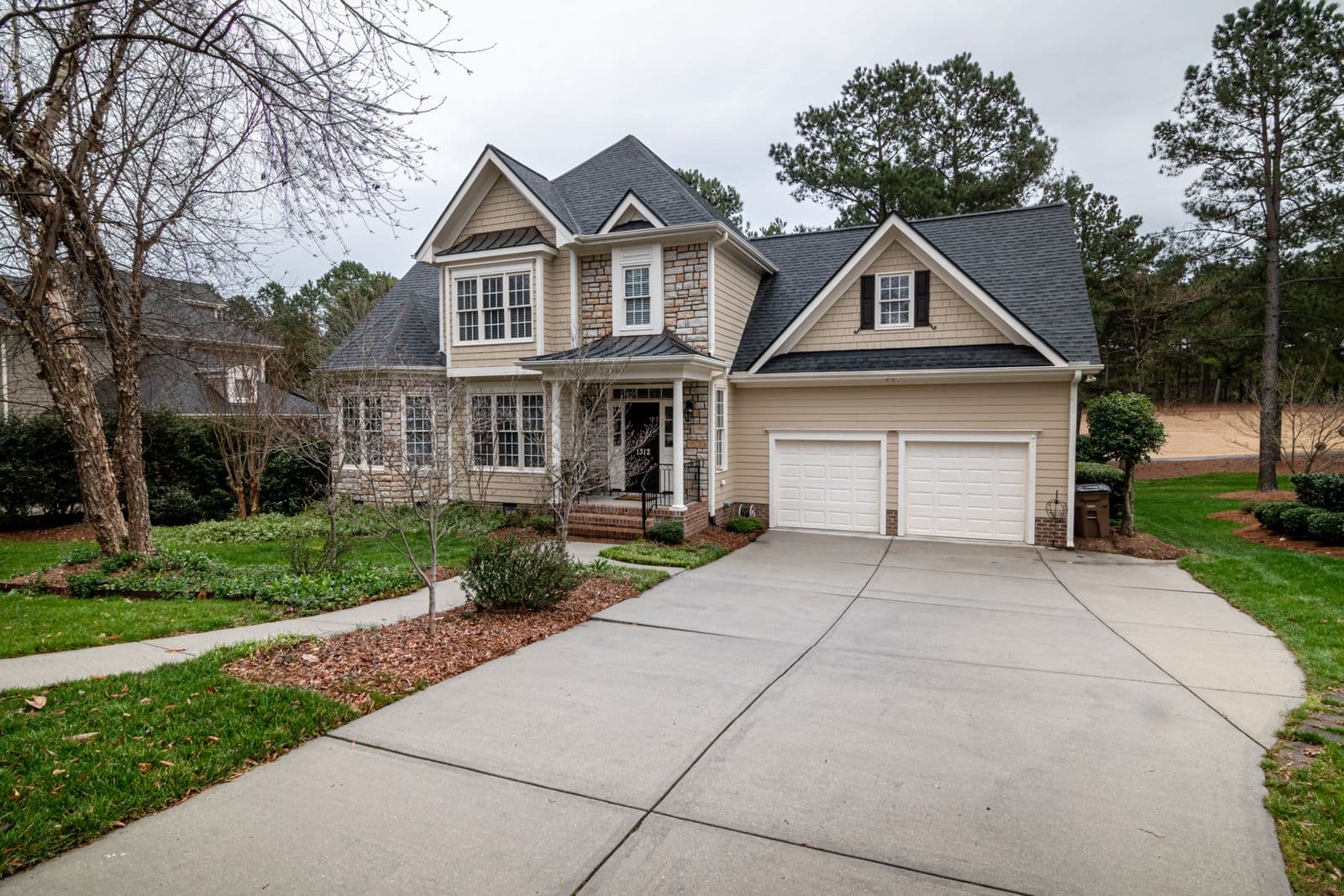 Two-story house with a long concrete driveway and two-car garage